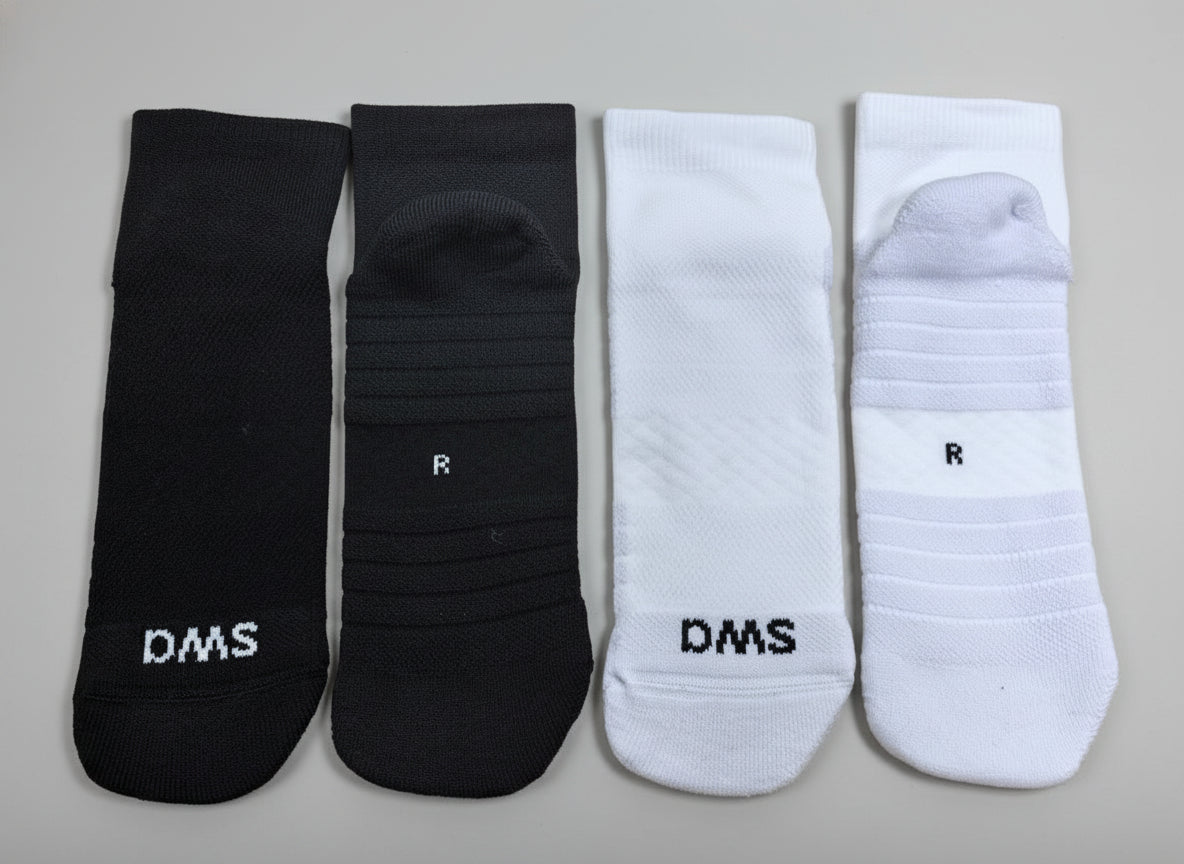 Two pairs of black and white socks with 'SWA' branding on a gray background