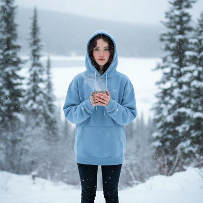 Person wearing a blue swa hoodie standing in a snowy landscape with trees.
