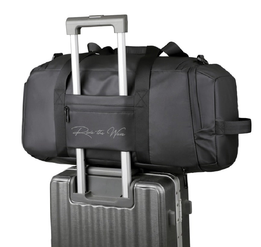 Black duffel bag with a handle on top of a suitcase on a white background